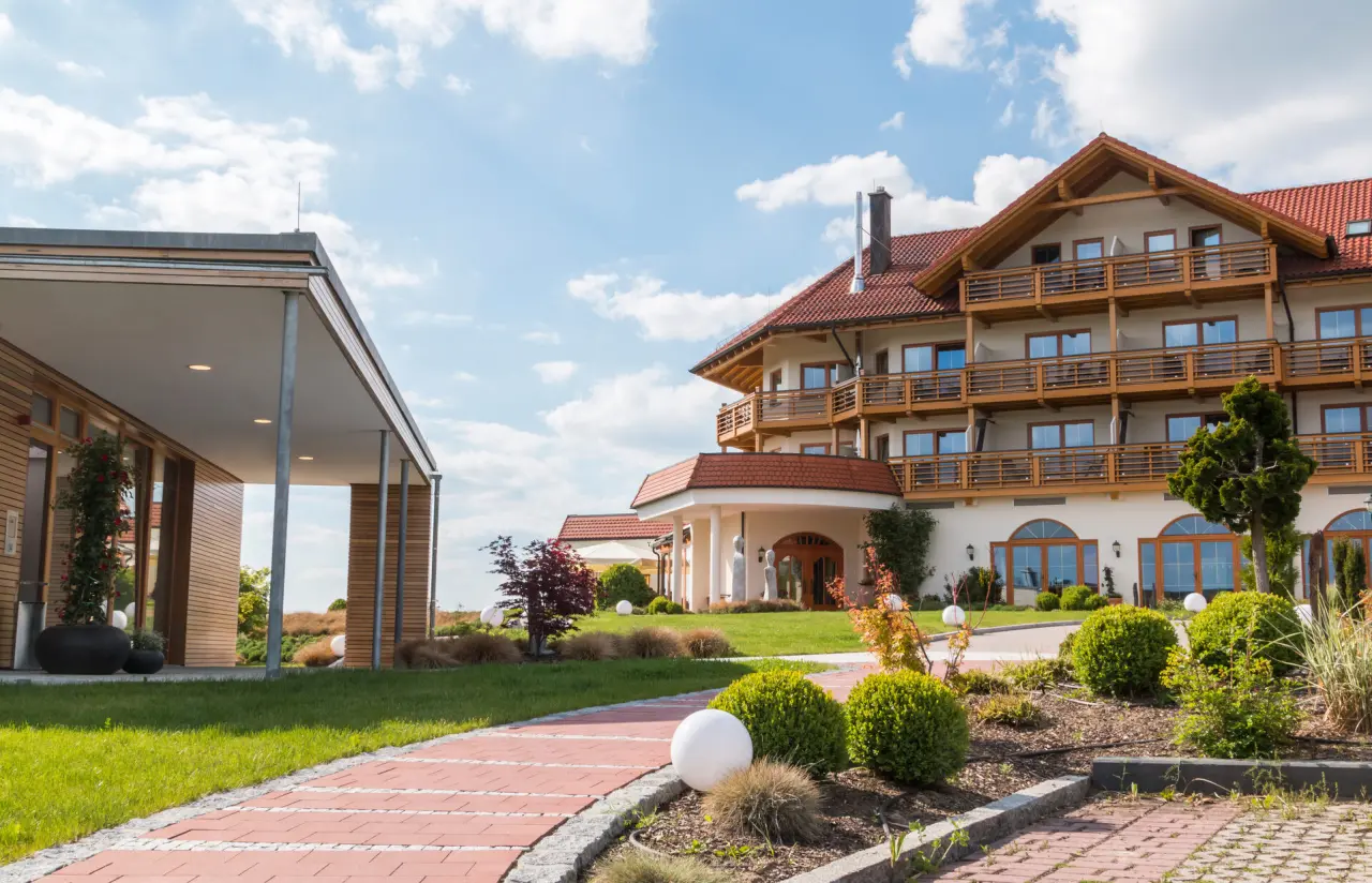 Aussenansicht des Der Birkenhof Spa & Genuss Resort. Traditionelles Hauptgebäude, moderner Anbau und gepflegte Gartenanlage.