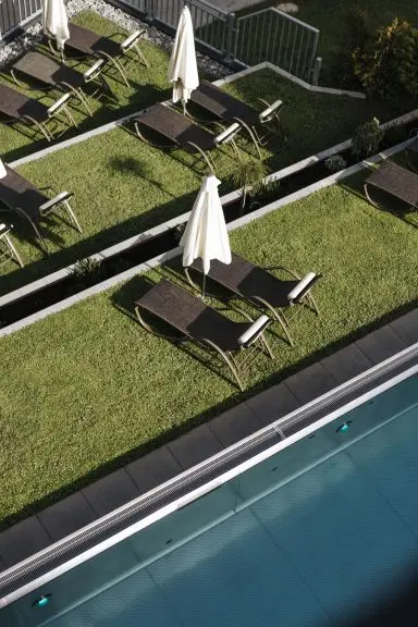 Sonnenterrasse mit Liegestühlen und Pool im Hotel Thurnerhof