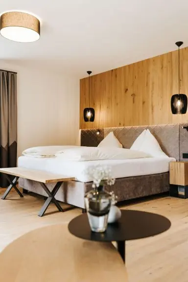 Gemütliches Doppelzimmer mit stilvoller Holzwand und bequemen Betten im Hotel Thurnerhof.