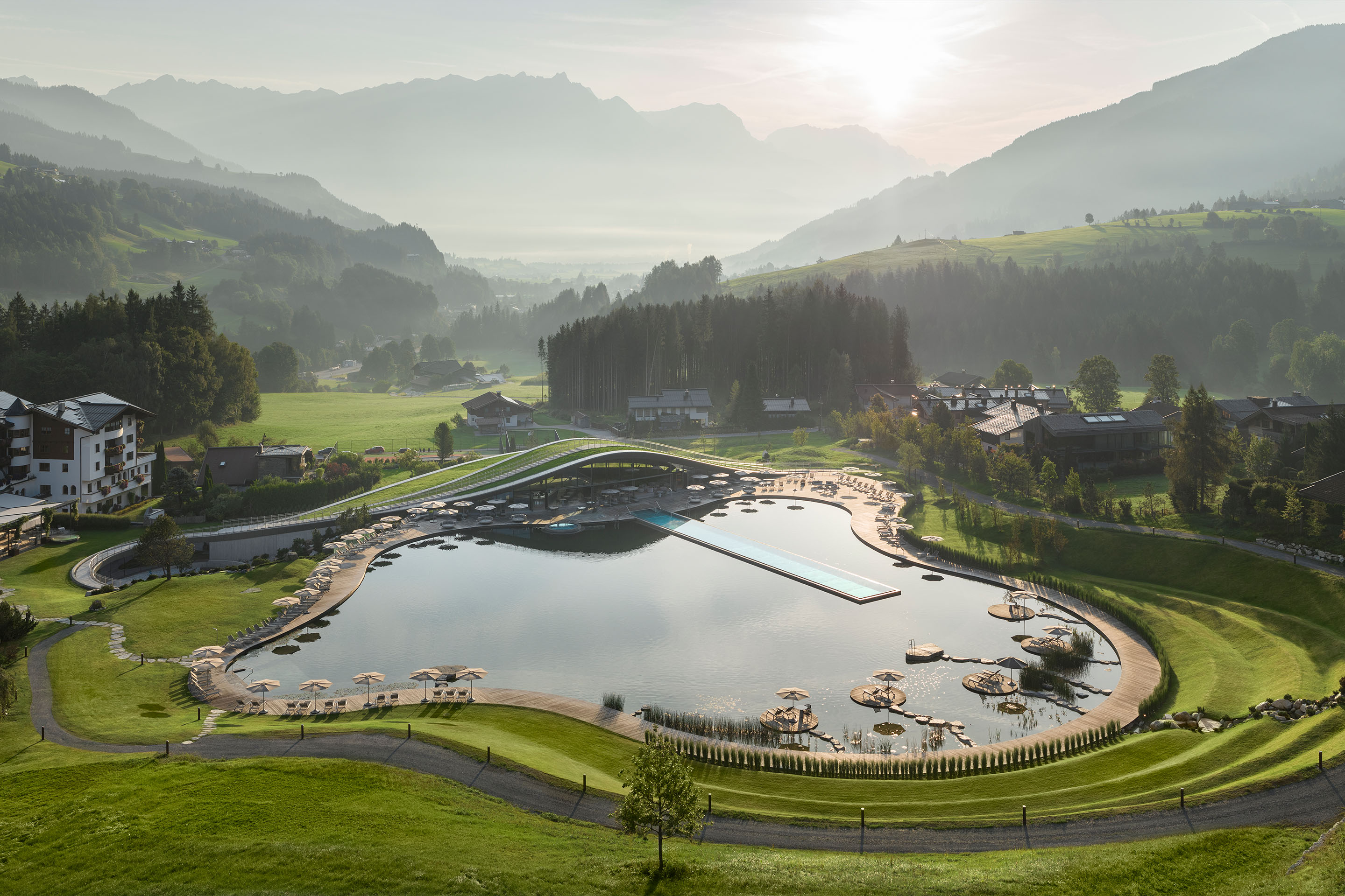 Wellnesshotel Krallerhof in Leogang – Naturbadeteich mit Bergpanorama bei Sonnenaufgang | Wellnesshotel Salzburger Land