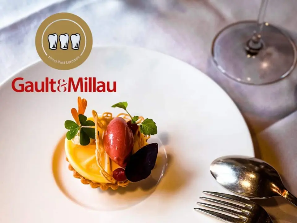 Exquisites Gault&Millau Dessert im Restaurant des Hotel Post Lermoos, kunstvoll angerichtet mit Fruchteis und frischen Kräutern.
