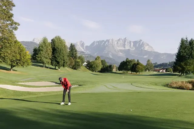 Hotel Kitzhof Mountain Design Resort in Kitzbühel – Golfer auf dem Golfplatz mit Bergpanorama | Wellnesshotel Tirol