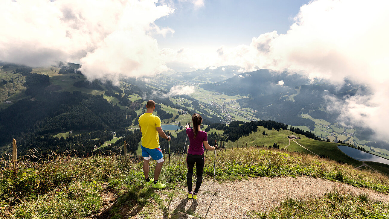 Das Hopfgarten Familotel Tirol in Hopfgarten – Paar beim Wandern mit Panoramablick auf die Berge | Wellnesshotel Tirol