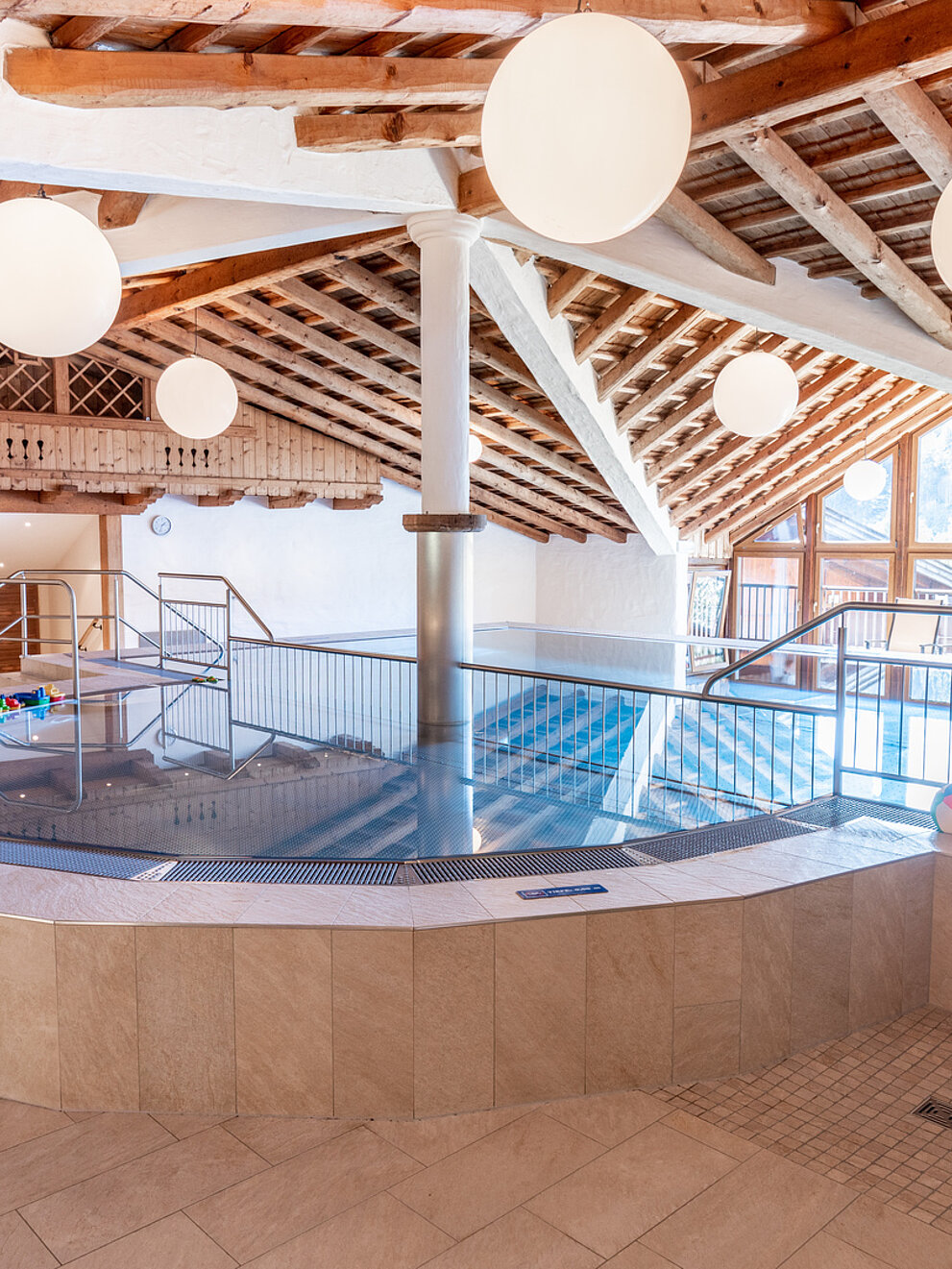 Das Hopfgarten Familotel Tirol in Hopfgarten – Innenpool mit Holzdach und großen Fenstern | Wellnesshotel Tirol
