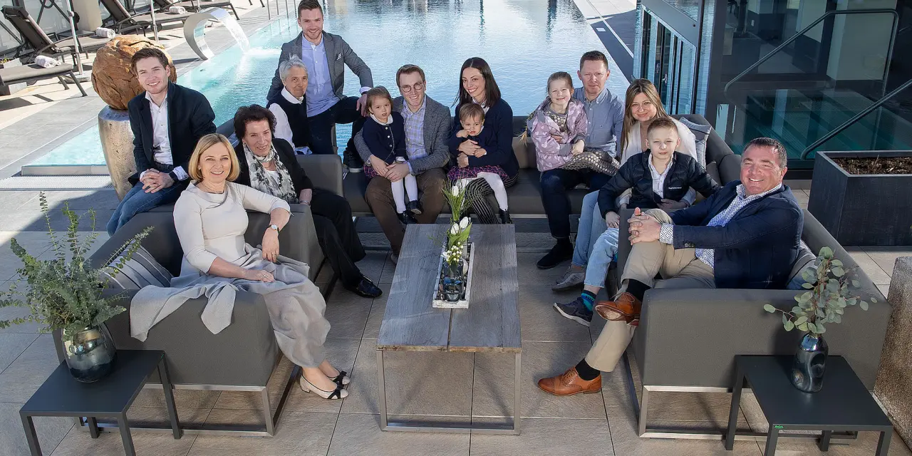 Lachende Familie auf der Sonnenterrasse mit modernem Aussenpool im Hotel Post Kaltenbach.