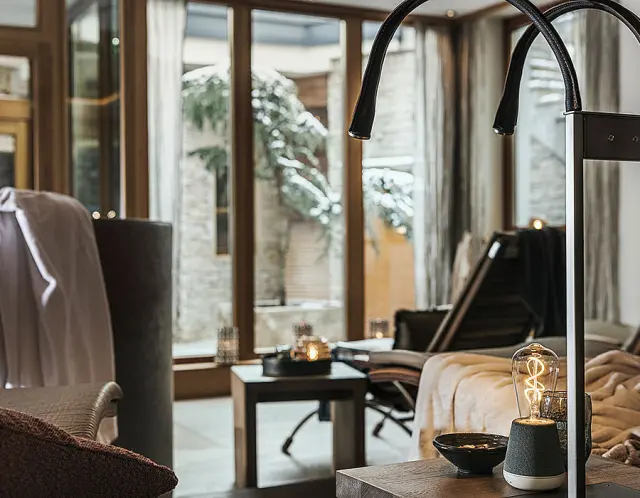 Gemütlicher Ruhebereich mit Blick auf verschneite Bäume im Wellnessbereich des Hotel Post Kaltenbach.