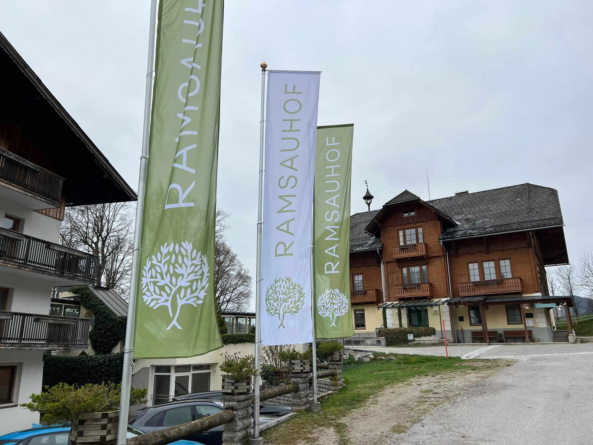Hotel Ramsauhof in Ramsau am Dachstein – Außenansicht mit Hotelfahnen | Wellnesshotel Dachstein