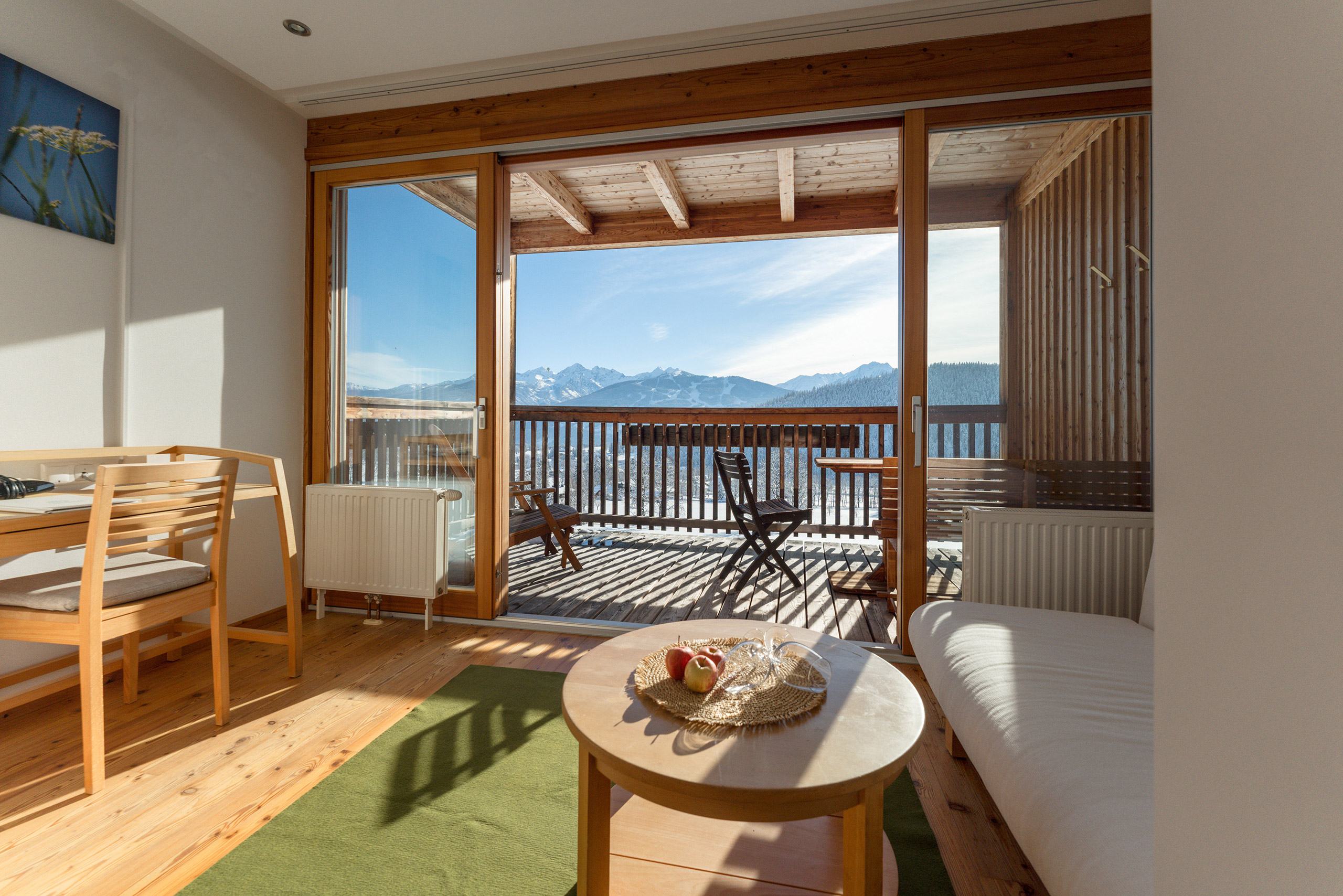 Hotel Ramsauhof in Ramsau am Dachstein – Helles Hotelzimmer mit Balkon und Bergblick im Winter | Wellnesshotel Dachsteinregion