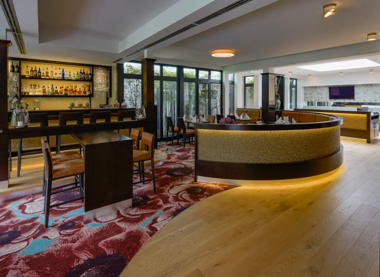 Moderne Hotelbar und Restaurantbereich im Essensio Hotel mit stilvoller Beleuchtung und bequemen Sitzgelegenheiten.