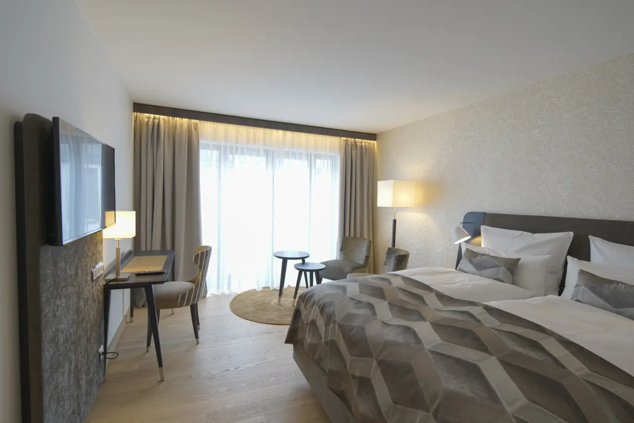Modernes Doppelzimmer im Essensio Hotel mit komfortablem Bett, Schreibtisch und Sitzgelegenheit.