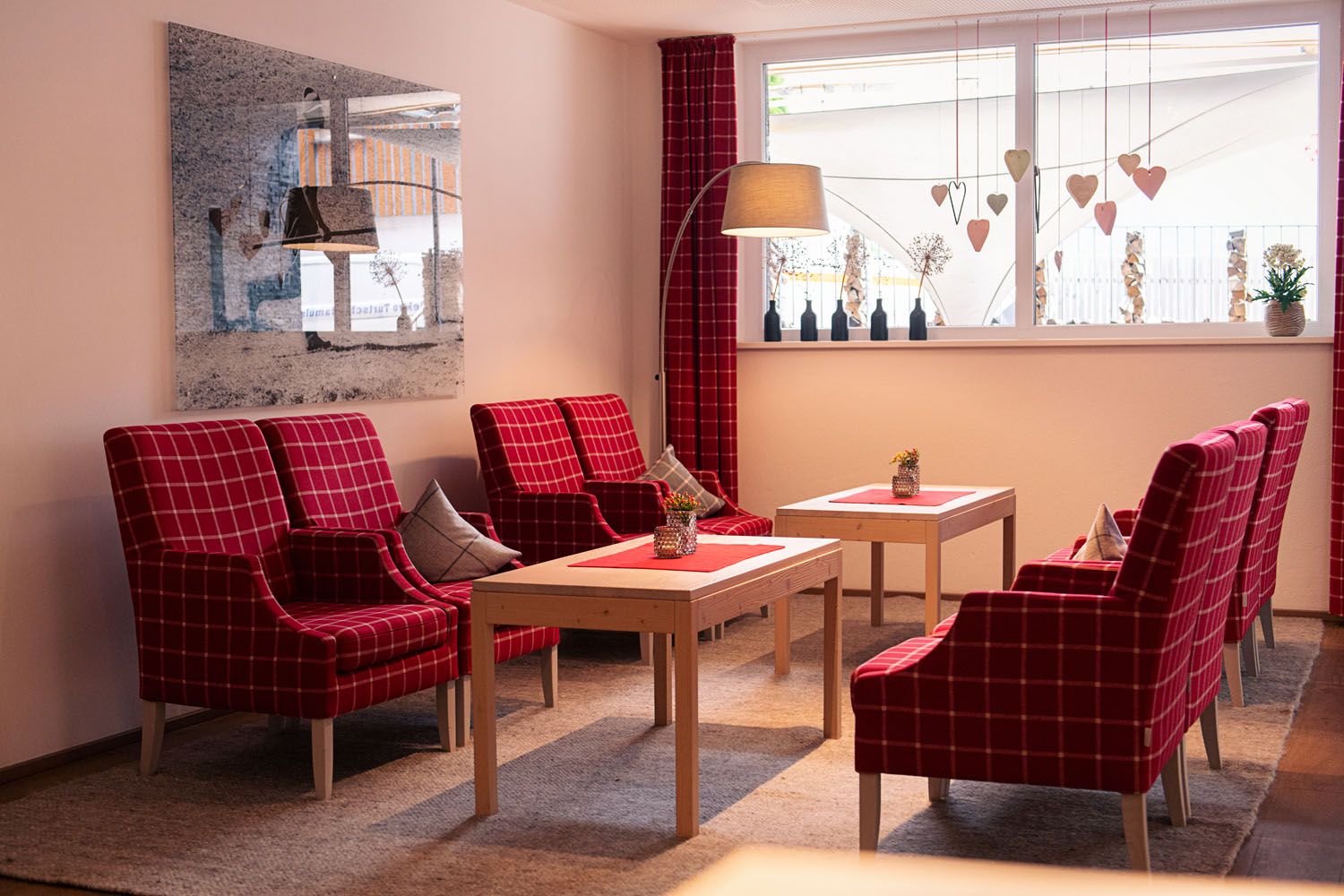 DAS SCHÄFER in Fontanella – Komfortable Lounge mit roten Sesseln und Tischen | Wellnesshotel Vorarlberg