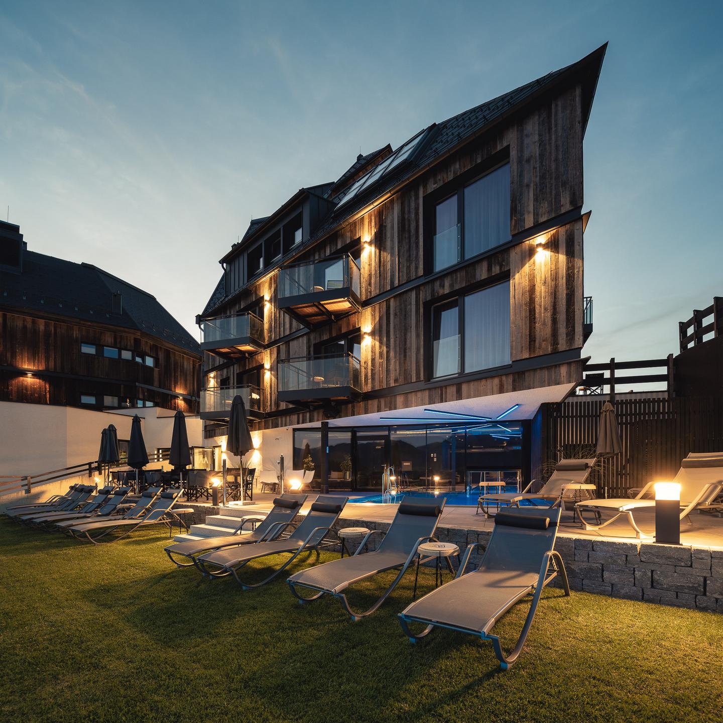 Das Marent in Fiss – Modernes Hotelgebäude mit beleuchtetem Außenpool bei Dämmerung | Wellnesshotel Tirol