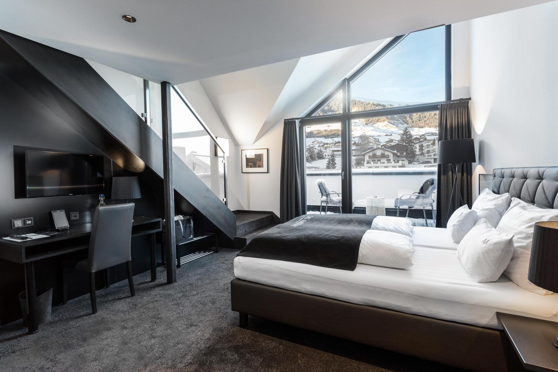 Das Marent in Fiss – Helles Doppelzimmer mit großem Fenster und Winterblick auf die Berge | Wellnesshotel Tirol