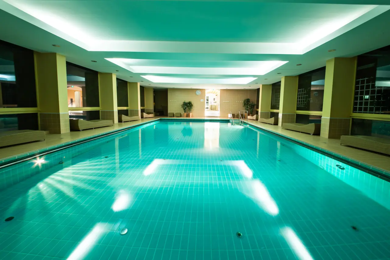Grosszügiger Innenpool im relexa hotel Bad Steben. Heller Wellnessbereich mit Liegen für entspannte Stunden.