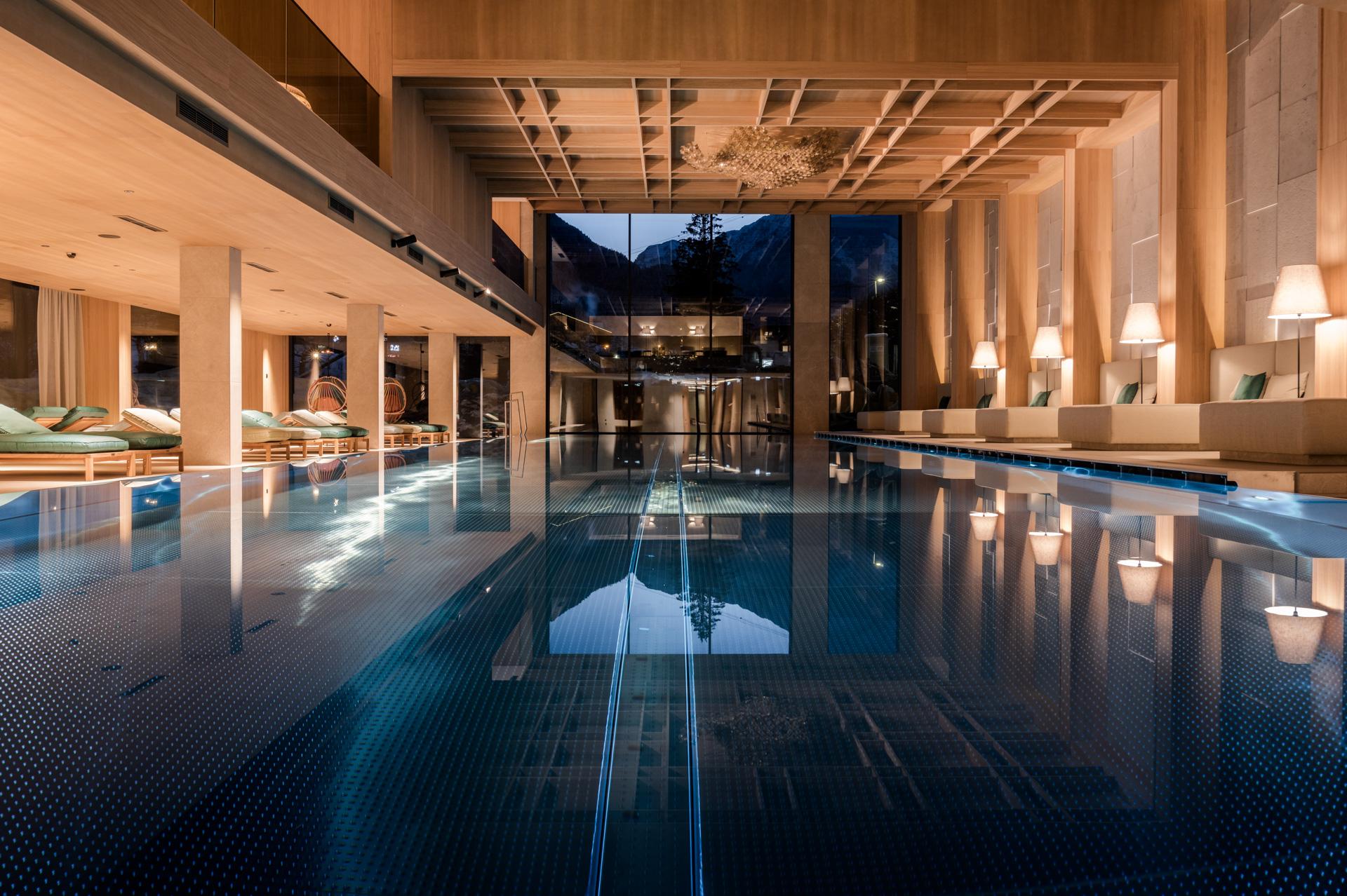 Neuhaus Zillertal Resort in Mayrhofen – Moderner Innenpool mit stilvoller Beleuchtung und Bergblick | Wellnesshotel Zillertal