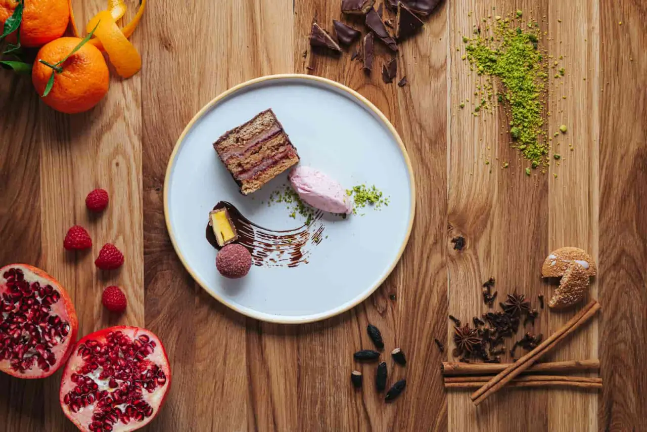 Kreativ angerichtetes Dessert mit Kuchen, Eis und frischen Fr

chten auf Holztisch im Romantik Hotel Seevilla.