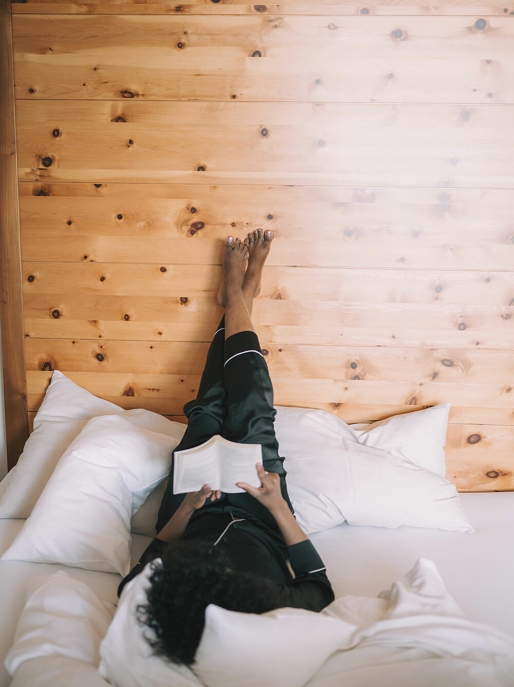 Hotel Enzian in Obertauern – Gast entspannt lesend im gemütlichen Hotelzimmer | Wellnesshotel Salzburger Land