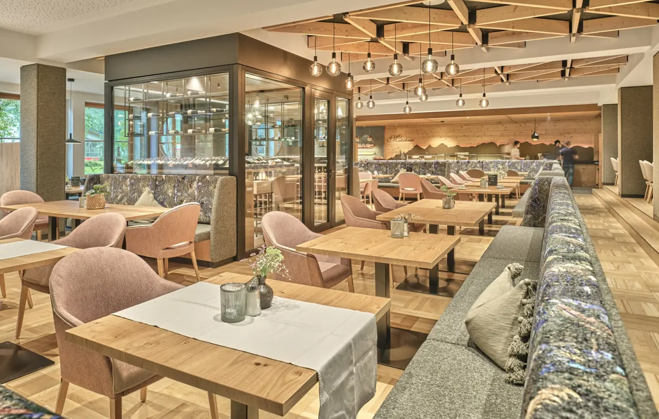 Modernes Restaurant mit Holzelementen, gemütlichen Sitzbereichen und Weinkeller im Hotel Matschner.