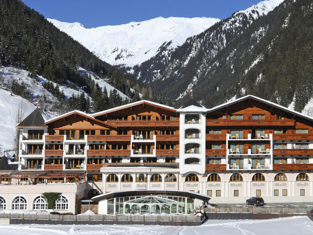 Aussenansicht des Wellness & Relax Hotel Milderer Hof im Winter, umgeben von verschneiten Bergen und Wäldern.