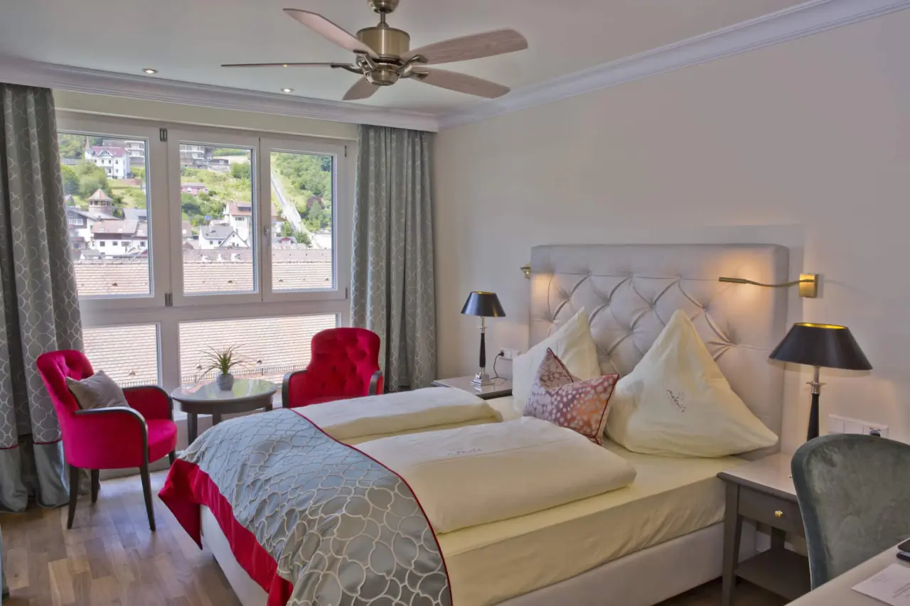 Komfortables Doppelzimmer im Mokni’s Palais Hotel & SPA mit gemütlicher Sitzecke und Blick auf die Stadt.