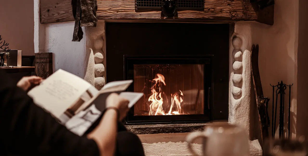 Entspannung am Kamin: Gast liest in der gemütlichen Lounge des Hotel St. Georg zum See.