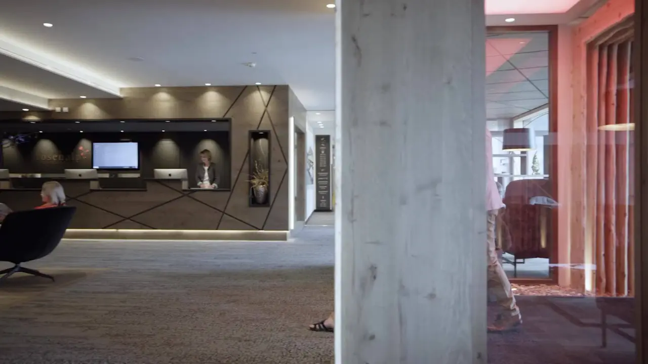 Moderne Lobby des Hotel Rosenalp mit Rezeption und Sitzgelegenheiten. Einladender Empfangsbereich für Gäste.