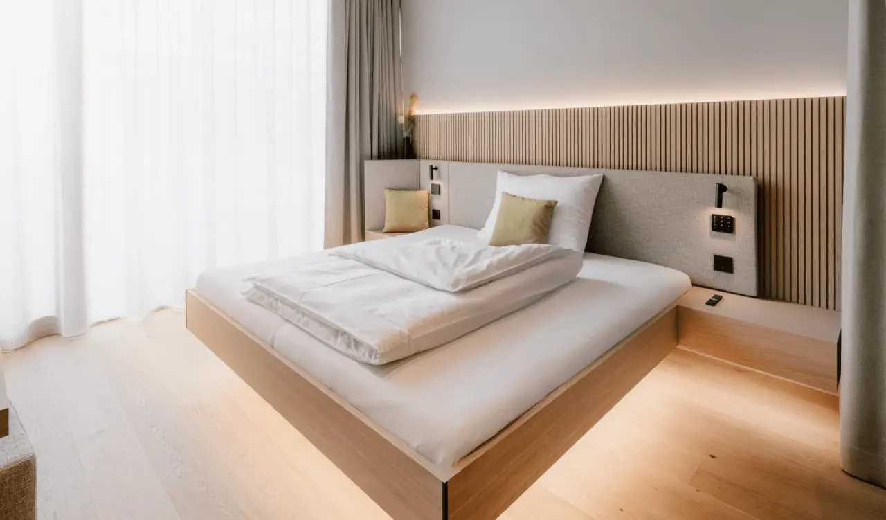Modernes Doppelzimmer im Loxone Campus mit Holzelementen, indirekter Beleuchtung und hellem Ambiente.