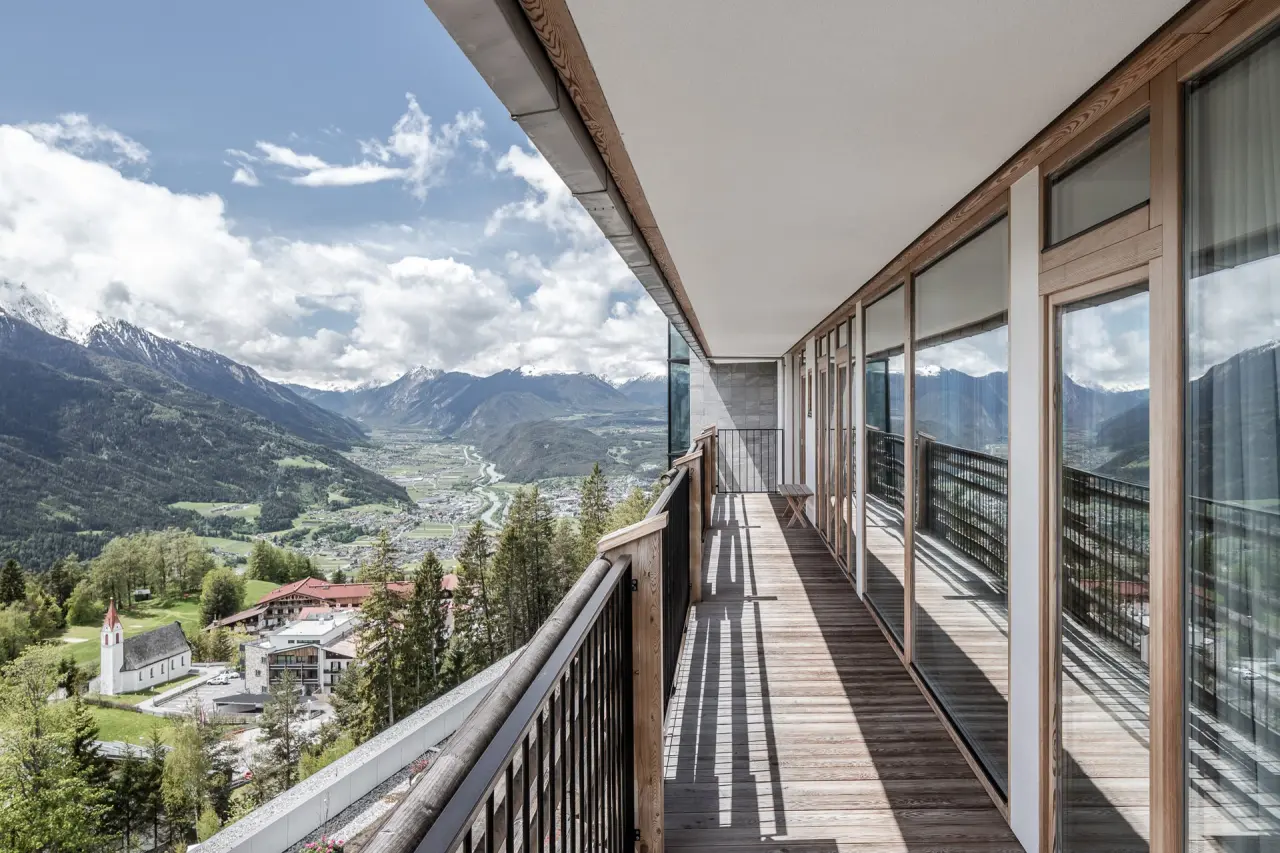 Geräumiger Balkon mit Holzboden und spektakulärem Panoramablick auf die Tiroler Alpen und das Inntal im Hotel Nidum.