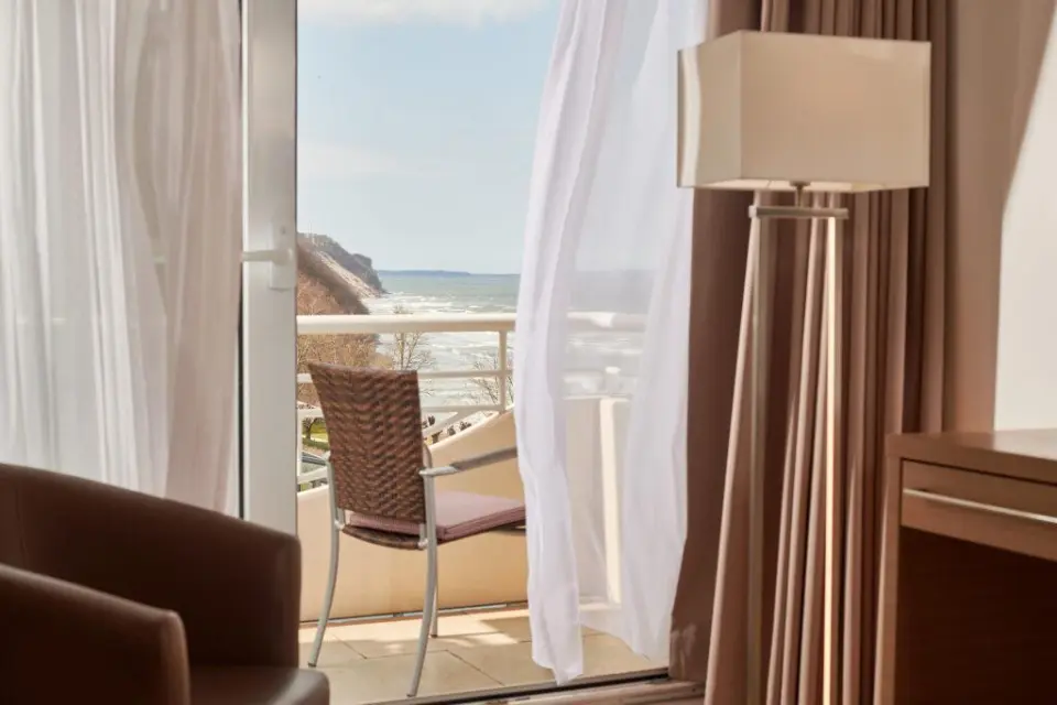 Blick vom Hotelzimmerbalkon des Hotel Bernstein auf die Ostsee und die Küste mit Klippen.