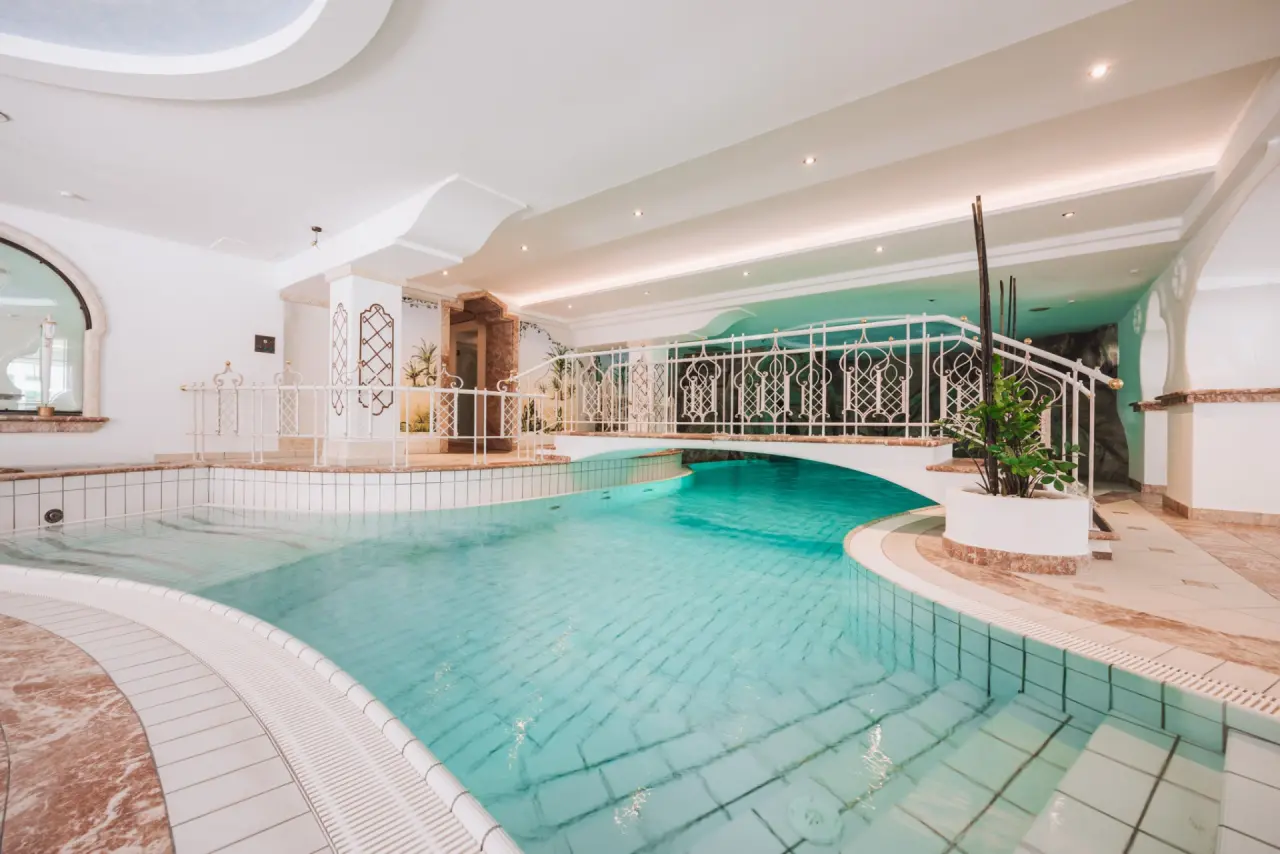 Einladender Innenpool mit dekorativer Brücke im Wellnessbereich des Hotel Gaspingerhof ****Superior.