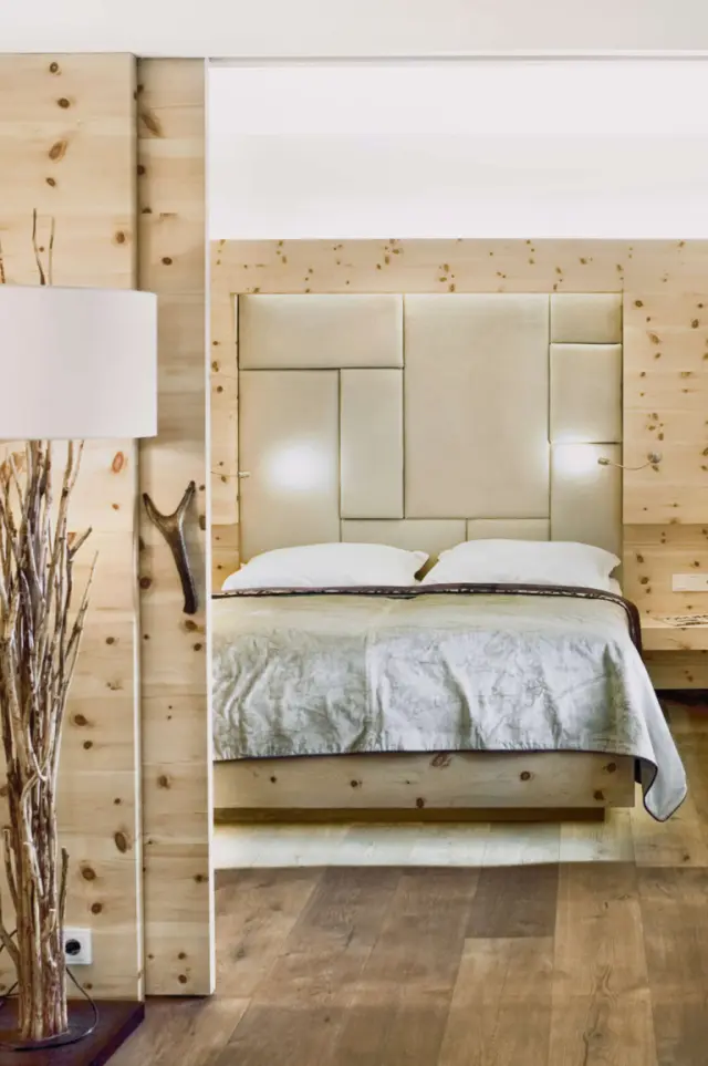 Modernes Doppelzimmer im alpinen Stil mit Holzelementen und gepolstertem Kopfteil im Lifestyle-Hotel Eder.