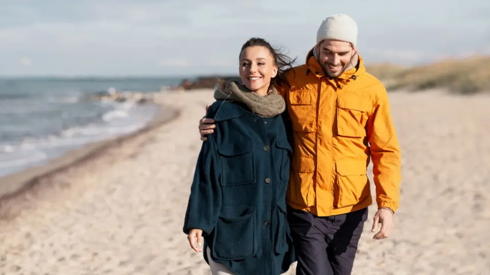 Lachendes Paar beim entspannten Strandspaziergang an der Ostsee, nahe dem Ostseehotel Midgard in Dampland.