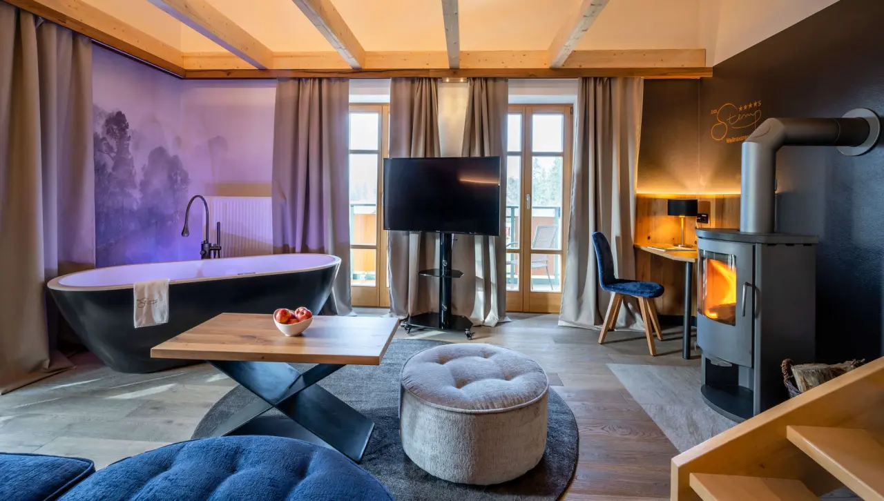 Luxuriöses Hotelzimmer mit freistehender Badewanne und Kamin im Das Stemp****S Wellnessresort.