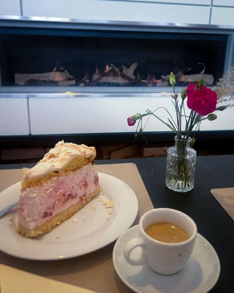 Gemütlicher Nachmittag mit Erdbeerkuchen und Espresso vor dem modernen Kamin im Logierhus Langeoog