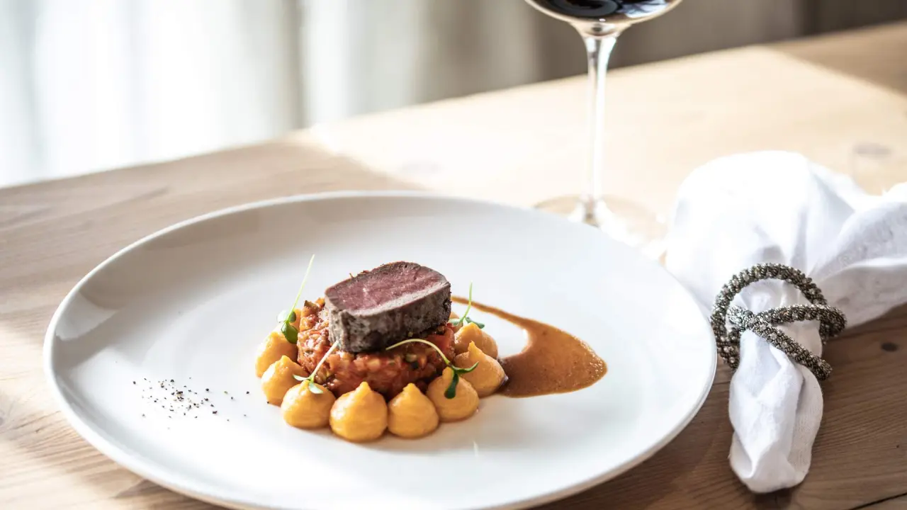 Exquisit angerichtetes Wildgericht mit Püree und Sauce im Restaurant des Vitalhotel Edelweiss.