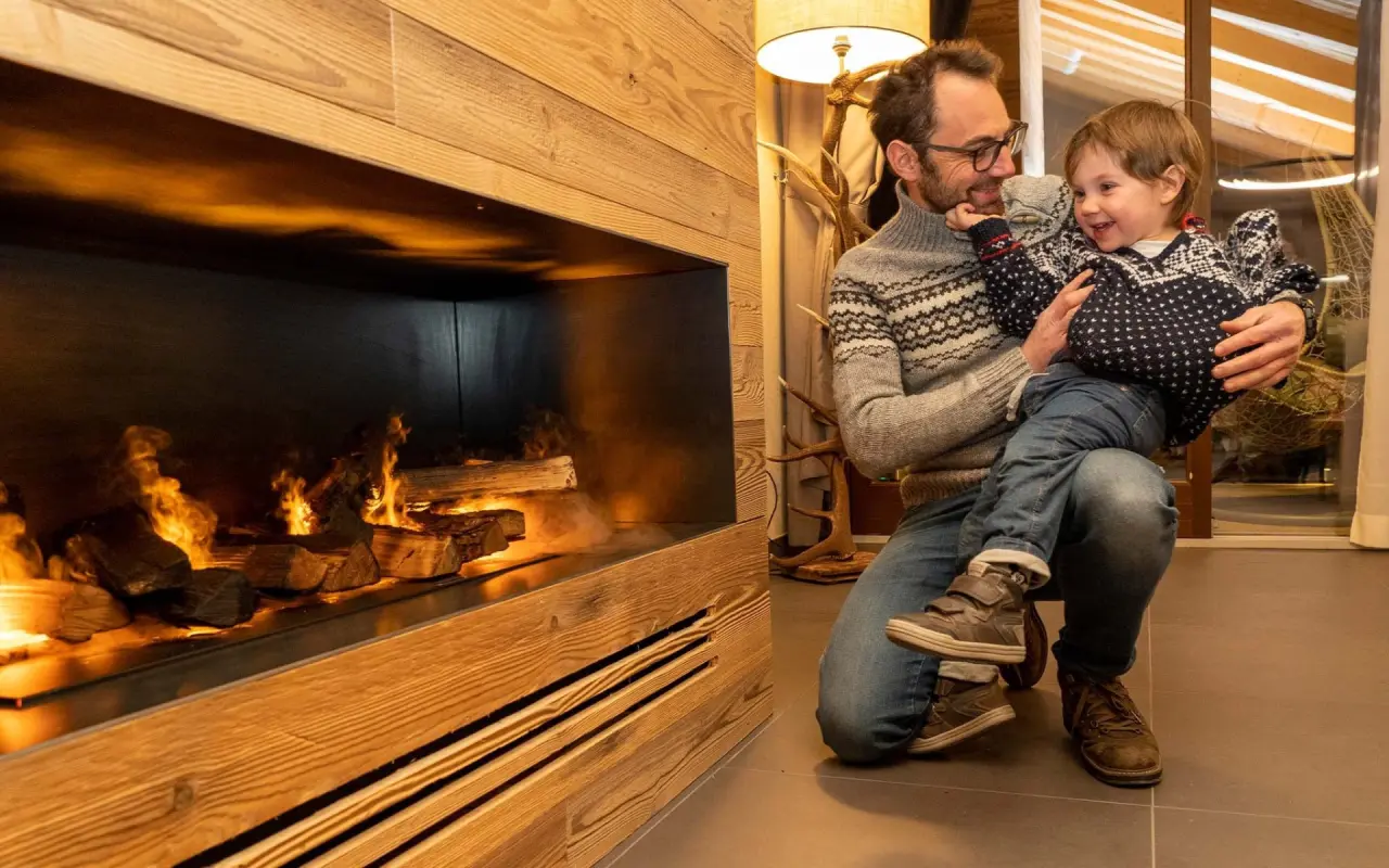 Nira - Mountain Resort Futura in Caspoggio – Vater und Kind am gemütlichen Kamin | Wellnesshotel Valmalenco
