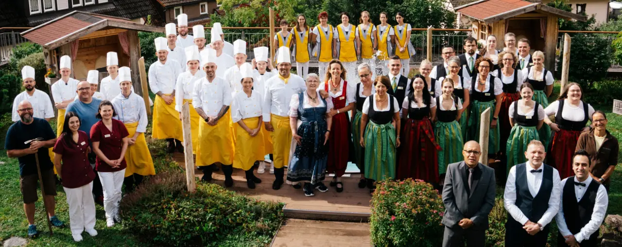 Freundliches Team des Wellness Hotel Tanne Tonbach: Küchenchefs, Service- und Spa-Mitarbeiter in Tracht und Uniform.