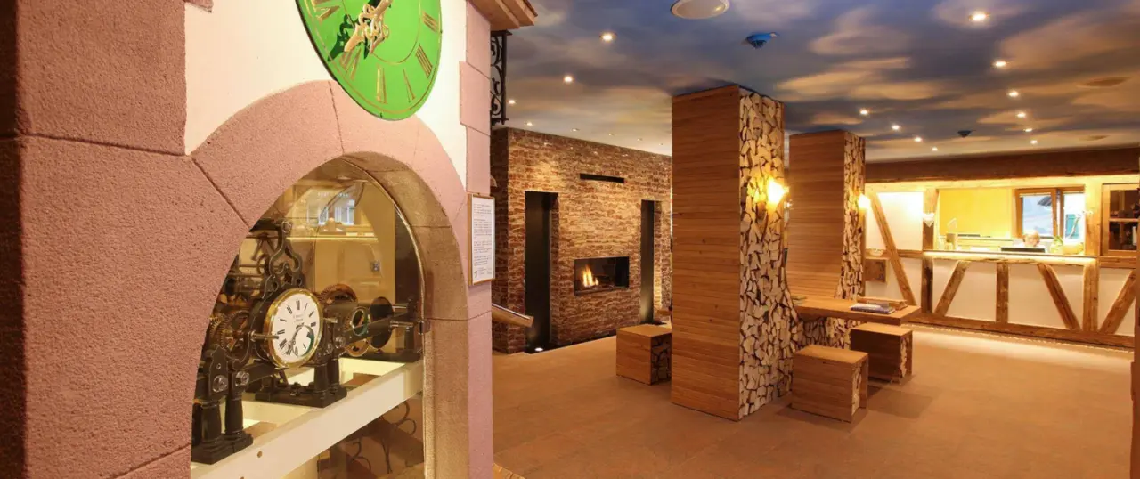 Einladender Empfangsbereich mit Kamin und rustikalen Holzelementen im Wellness Hotel Tanne Tonbach.