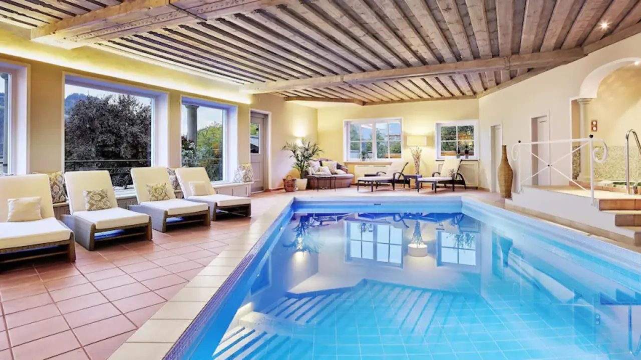 Beheizter Innenpool mit Holzdecke und Liegeflächen im Tennerhof Gourmet & Spa de Charme Hotel.