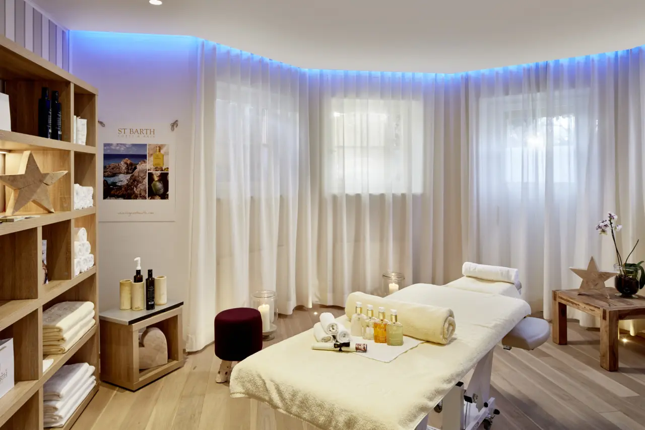 Entspannender Behandlungsraum mit Massageliege und St. Barth Produkten im Spa des Tennerhof Gourmet & Spa de Charme Hotel.