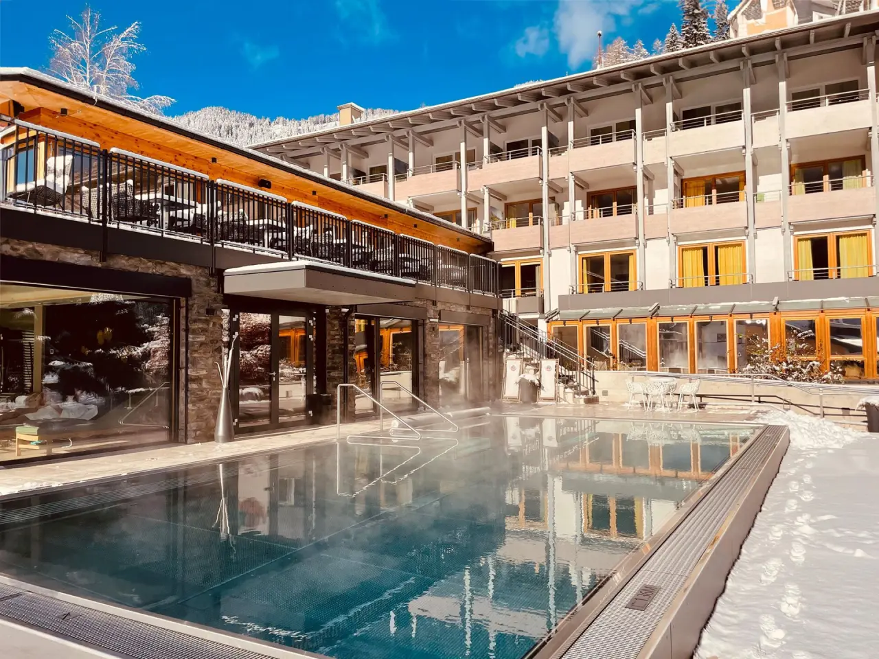 Beheizter Aussenpool mit Dampf und verschneiter Bergkulisse im Evident Hotel Prägant****