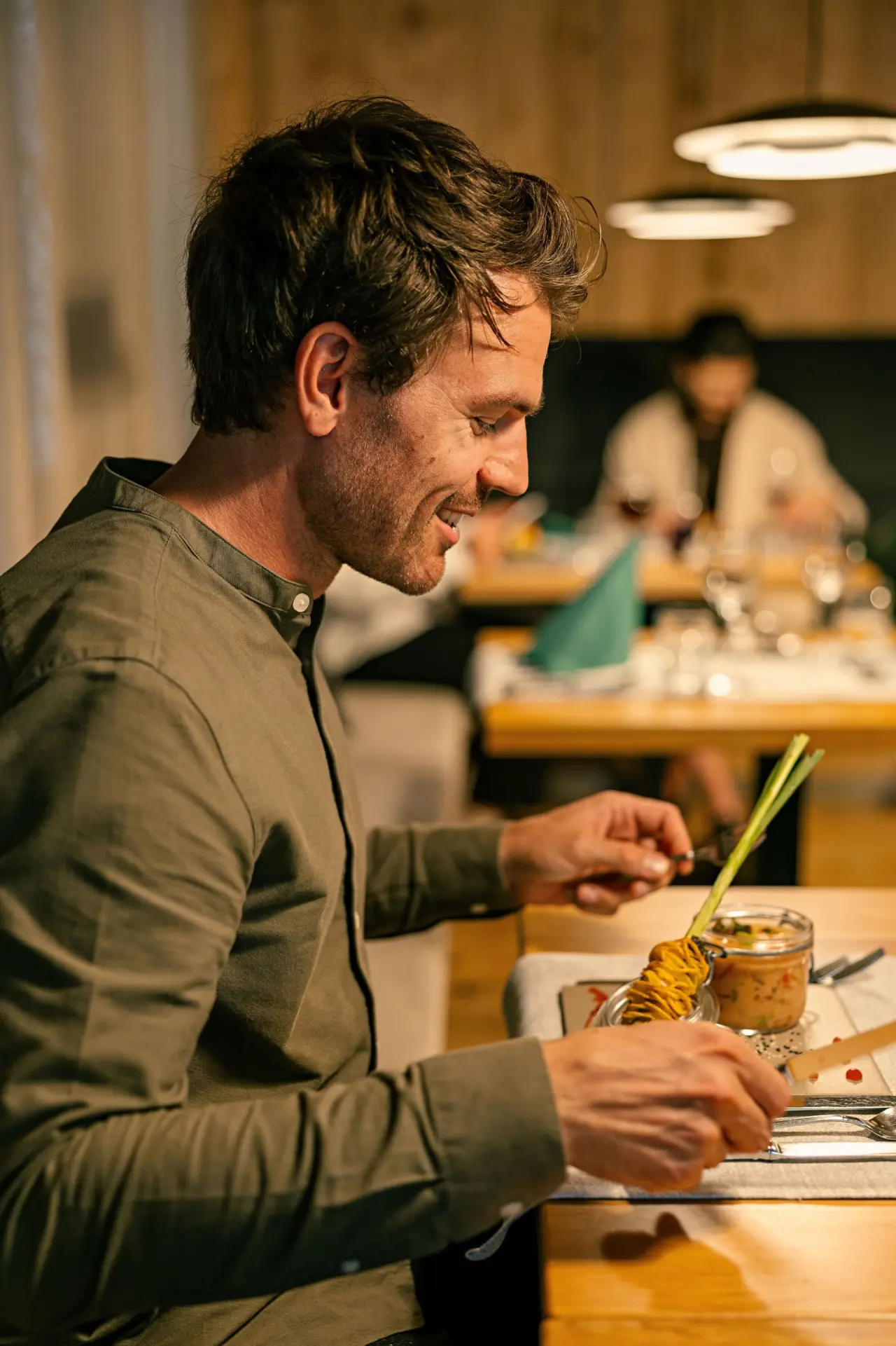 Lächelnder Gast genießt ein stilvolles Abendessen im Restaurant des Evident Hotel Prägant****.