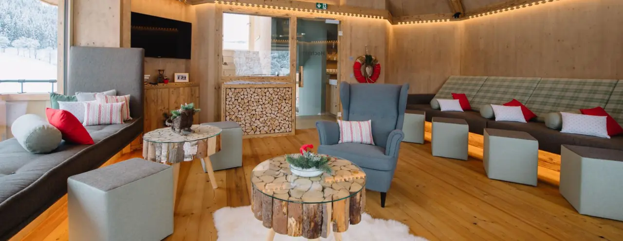 Gemütlicher Ruheraum im Wellnessbereich des Hotel Tirolerhof mit Blick auf die verschneite Winterlandschaft.