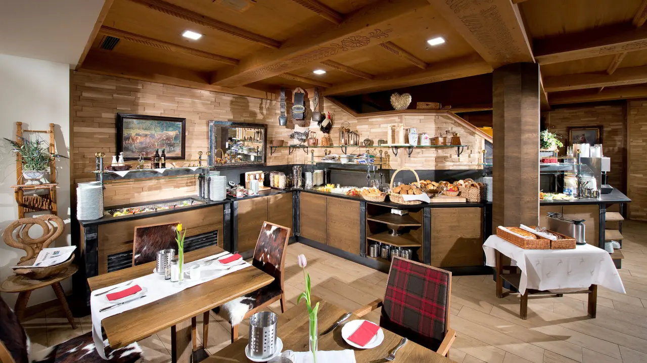 Reichhaltiges Frühstücksbuffet im traditionellen Restaurant des Schmelmer Hof mit Holzinterieur und gemütlichen Sitzplätzen.