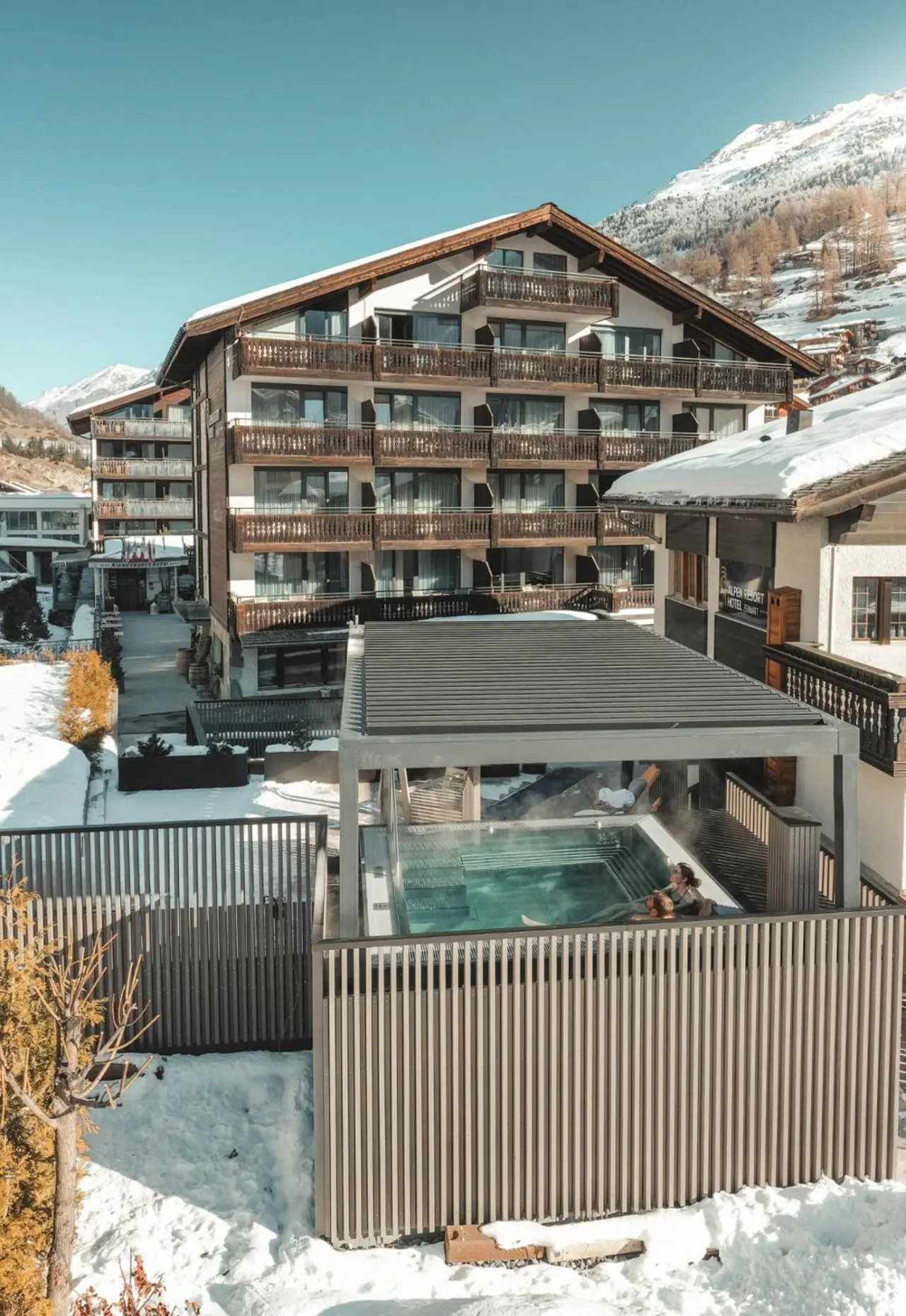 Beheizter Aussenpool des Alpen Resort Hotel mit Blick auf die verschneite Berglandschaft in Zermatt.