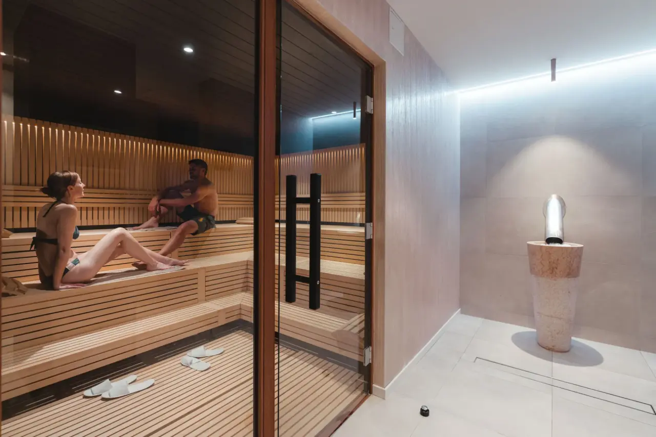 Finnische Sauna mit entspannenden Gästen und modernem Design im Spa-Bereich des Alpen Resort Hotel.
