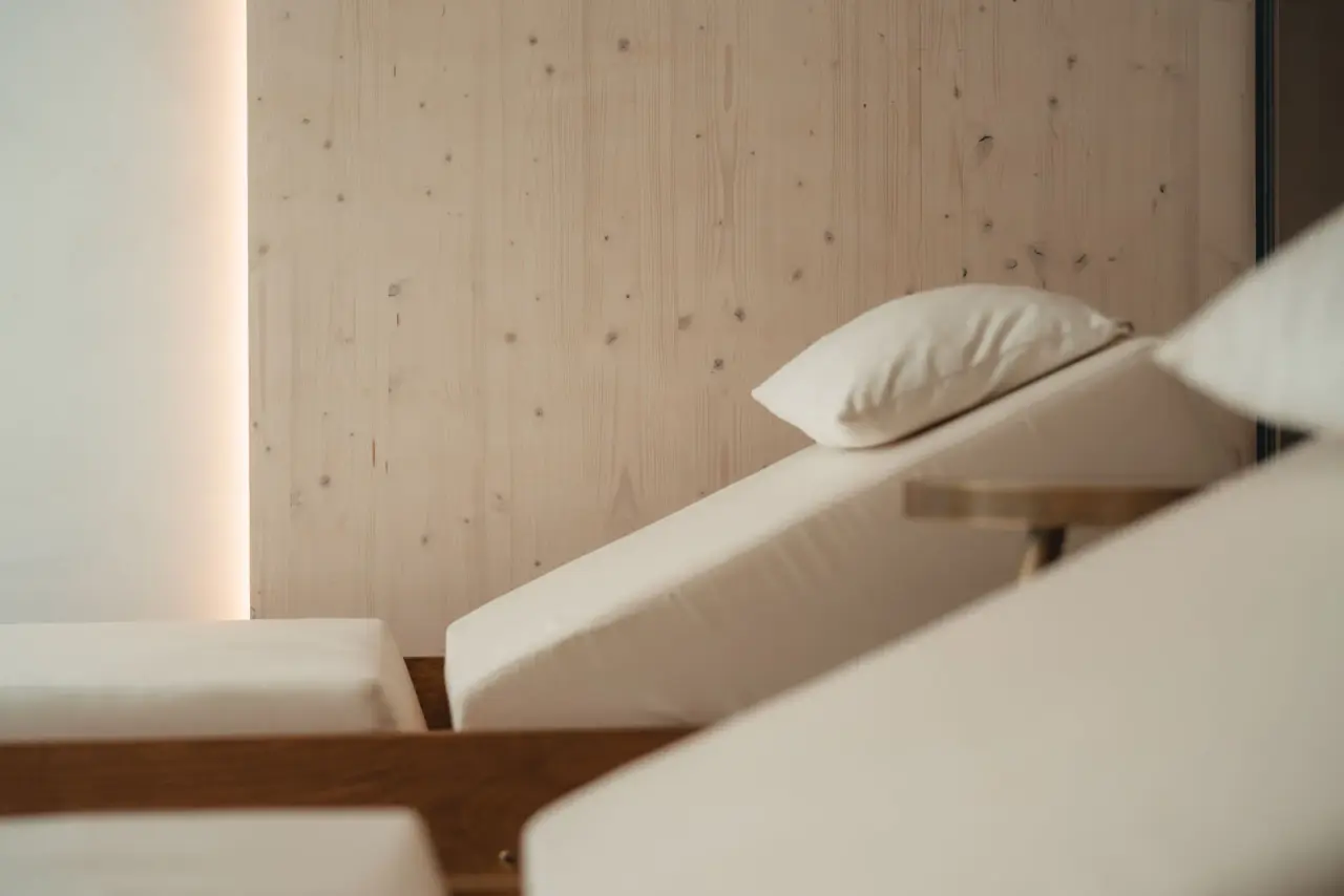 Entspannende Liegen im Ruhebereich des Alpen Resort Hotel Spa mit heller Holzvertäfelung und indirekter Beleuchtung.