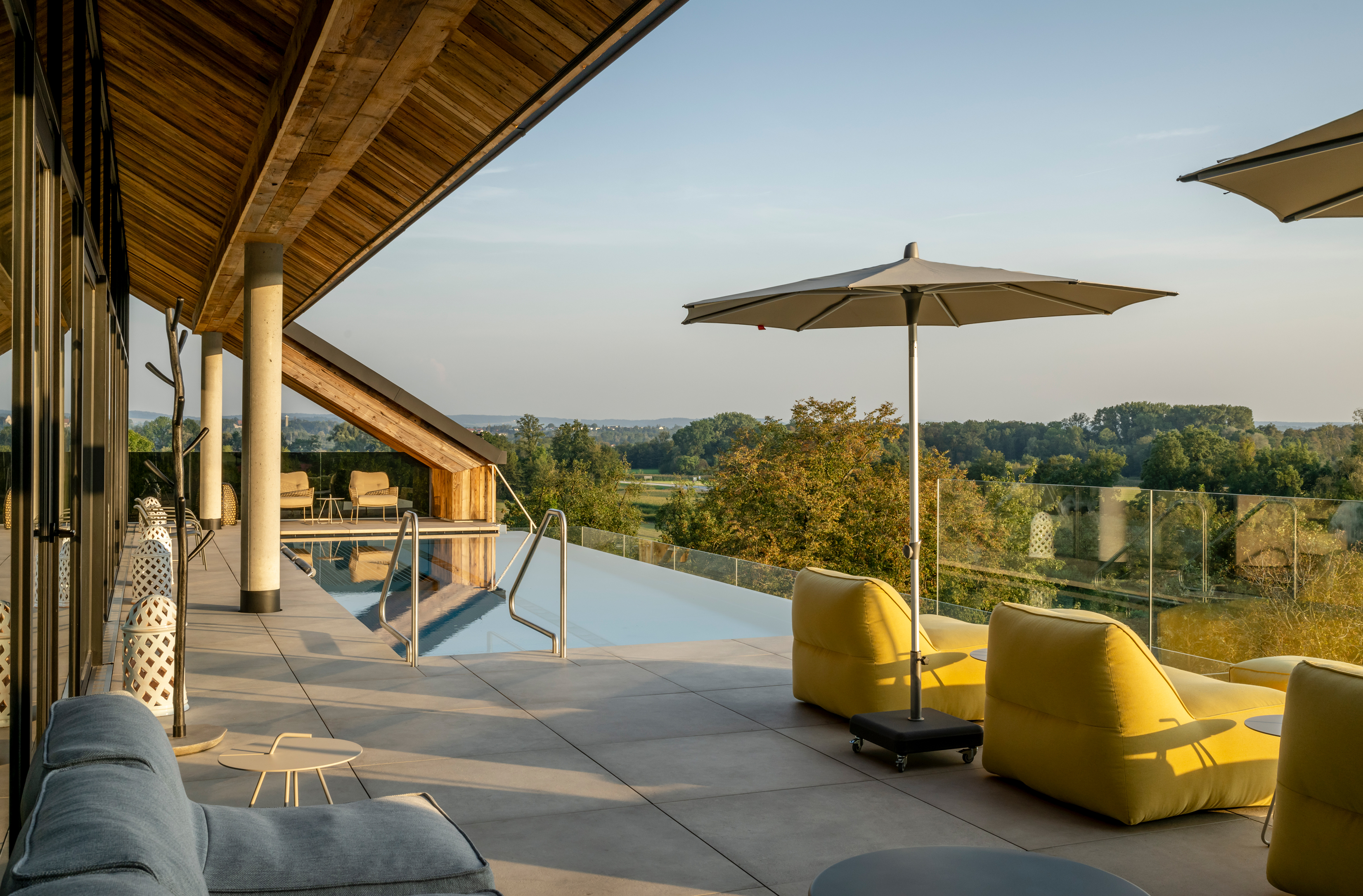 Das Mühlbach Thermal Spa in Bad Füssing – Sonnenterrasse mit Infinity-Pool und bequemen Liegen | Wellnesshotel Niederbayern