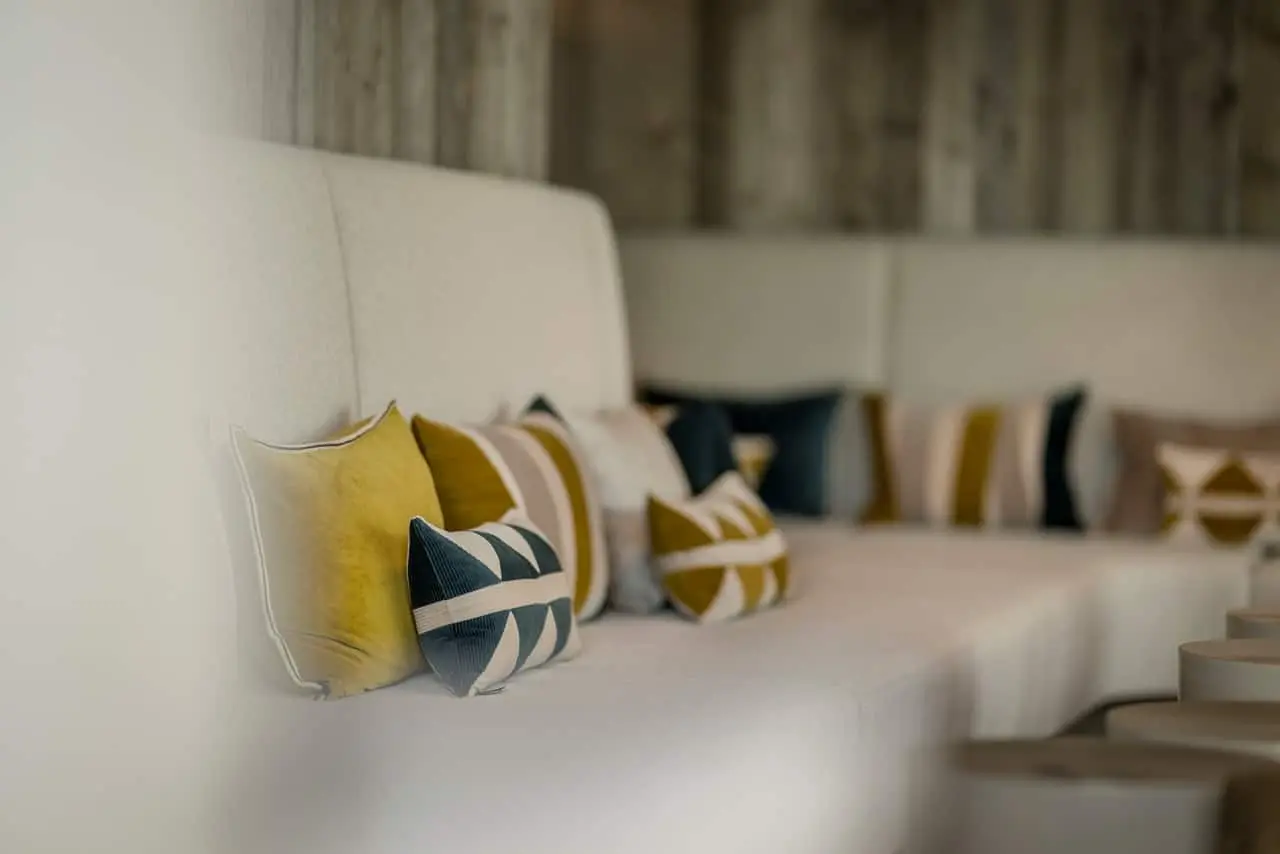 Moderne Lounge-Sitzecke mit stilvollen Kissen in Gelb und Blau im Das Mühlbach Thermal Spa, ideal zum Entspannen.