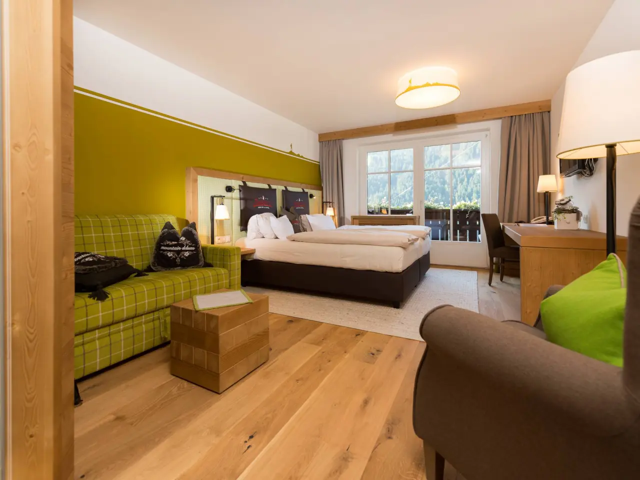 Gemütliches Doppelzimmer im BergSPA & Hotel Zamangspitze mit Bergblick, Holzboden und bequemer Sitzecke.